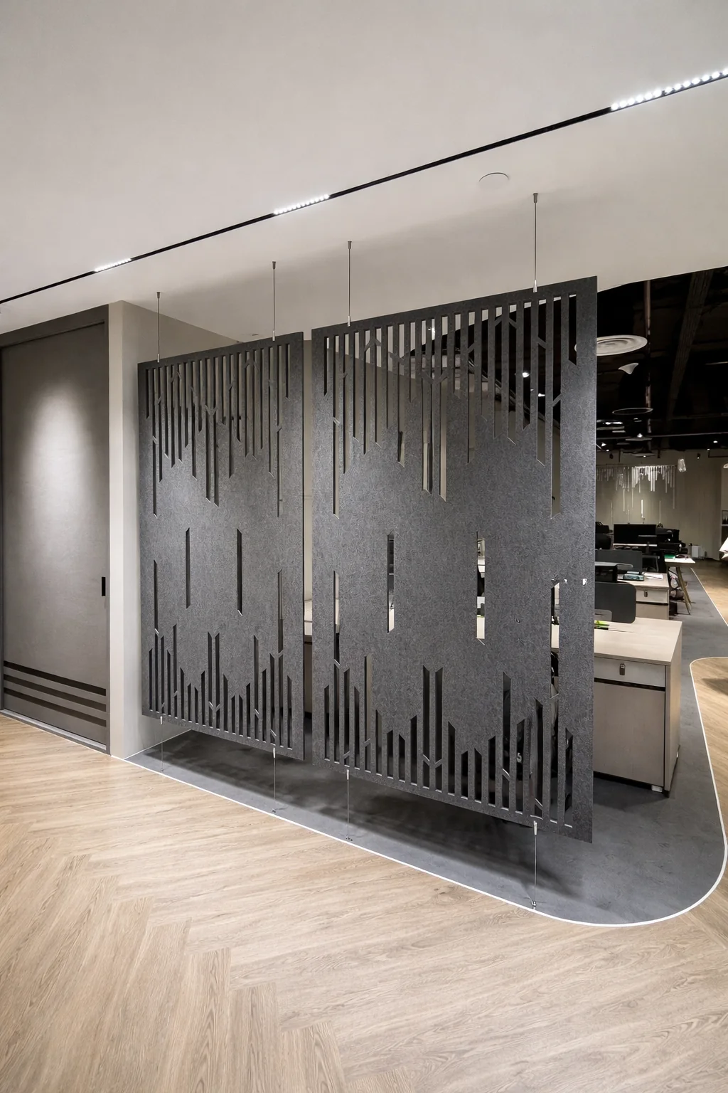 Grey hanging acoustic divider screens with CNC cut pattern